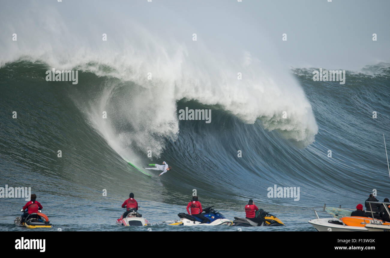 Surfer en compétition dans les Mavericks 2014 Concours surf, regardée par les gens sur des jet-skis, Half Moon Bay, Californie, USA, janvier 2014. Banque D'Images