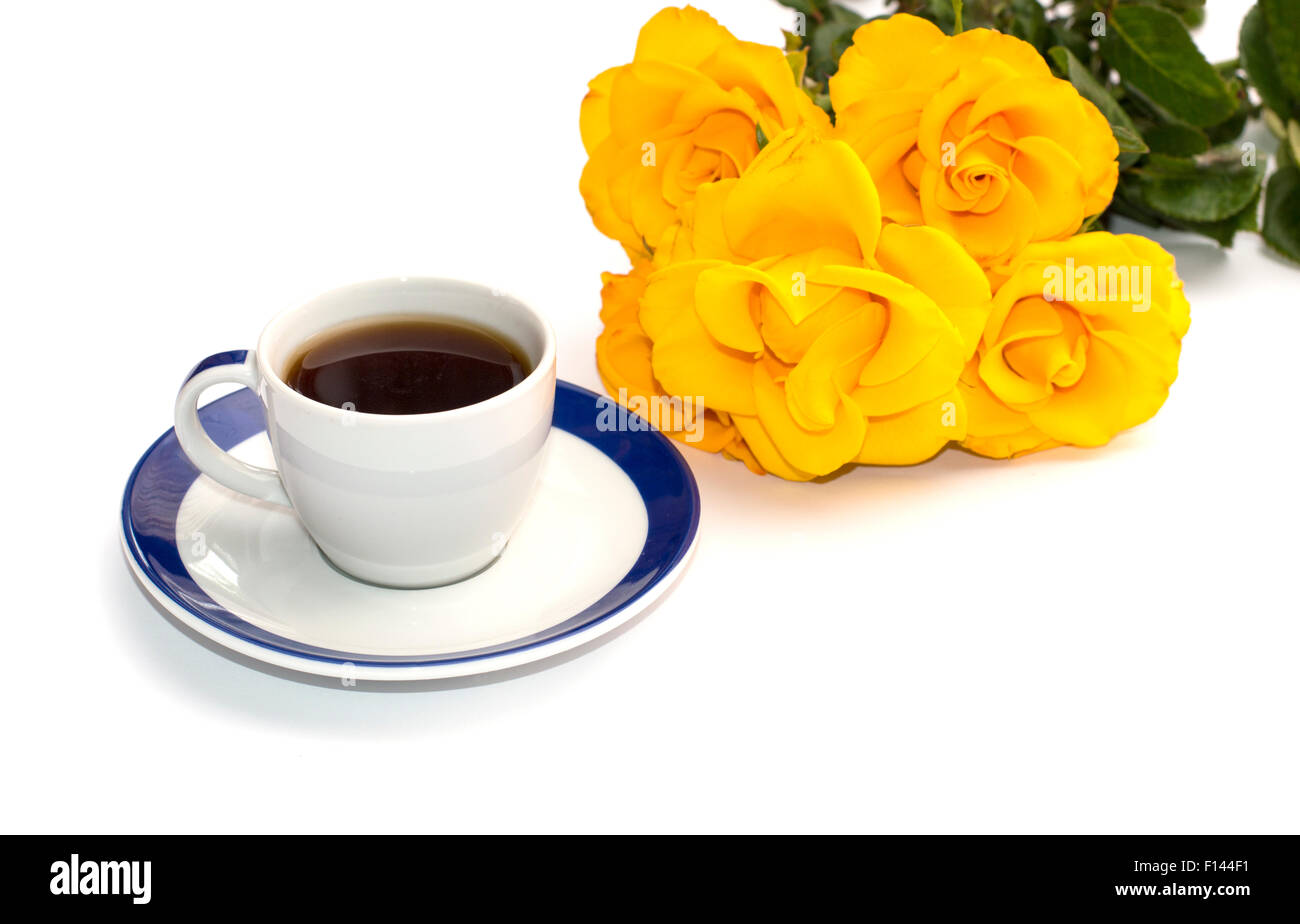 Tasse de café sur une soucoupe et un bouquet de roses jaunes, de l'image isolée Banque D'Images