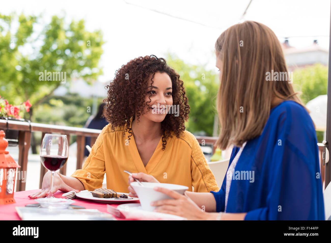Personnes assises en train de boire un verre en terrasse en souriant et ...