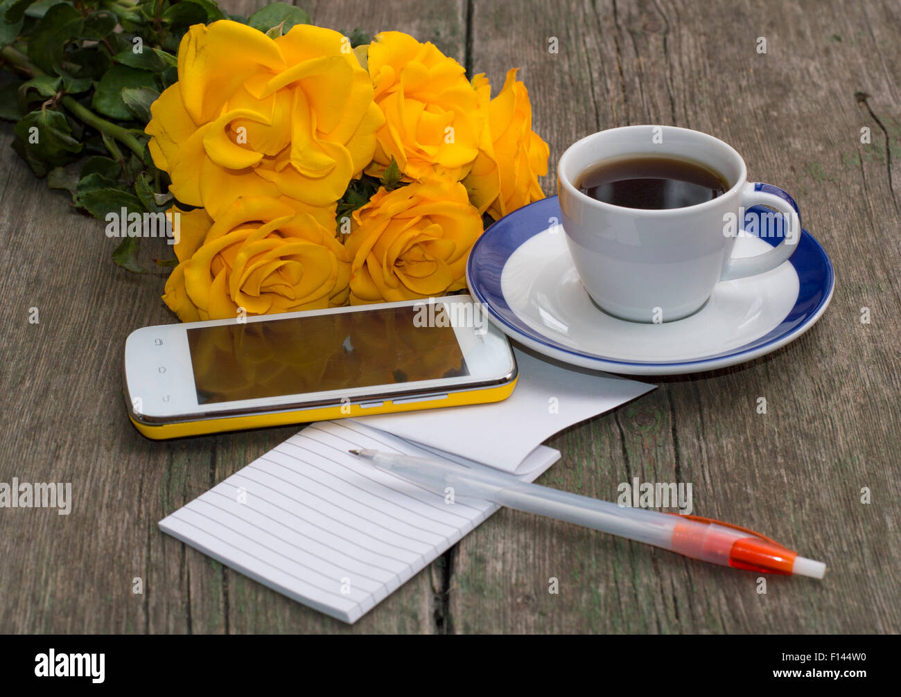 Tasse de café, téléphone, bouquet de roses et d'ordinateur portable avec la poignée Banque D'Images