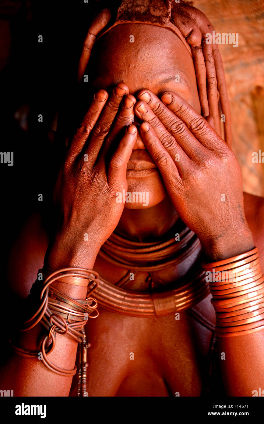 Femme Himba (Otjize appliquer un mélange de beurre, d'ocre et de cendres) à sa peau, Kaokoland, Namibie, septembre 2013. Banque D'Images