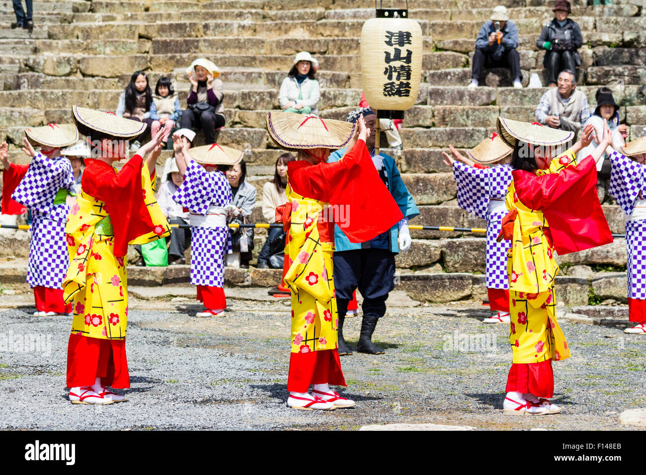 Le Japon, Tsuyama. Cherry Blossom Festival de printemps en ligne Parc Kakuzan des enfants dans la tradition du yukata vestes et portant des chapeaux de paille, la danse. Banque D'Images