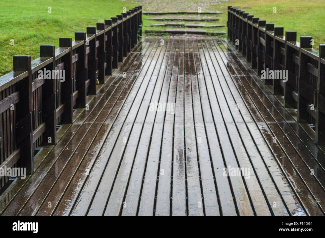 Vue brouillée de pont en bois humide sur un temps pluvieux Banque D'Images
