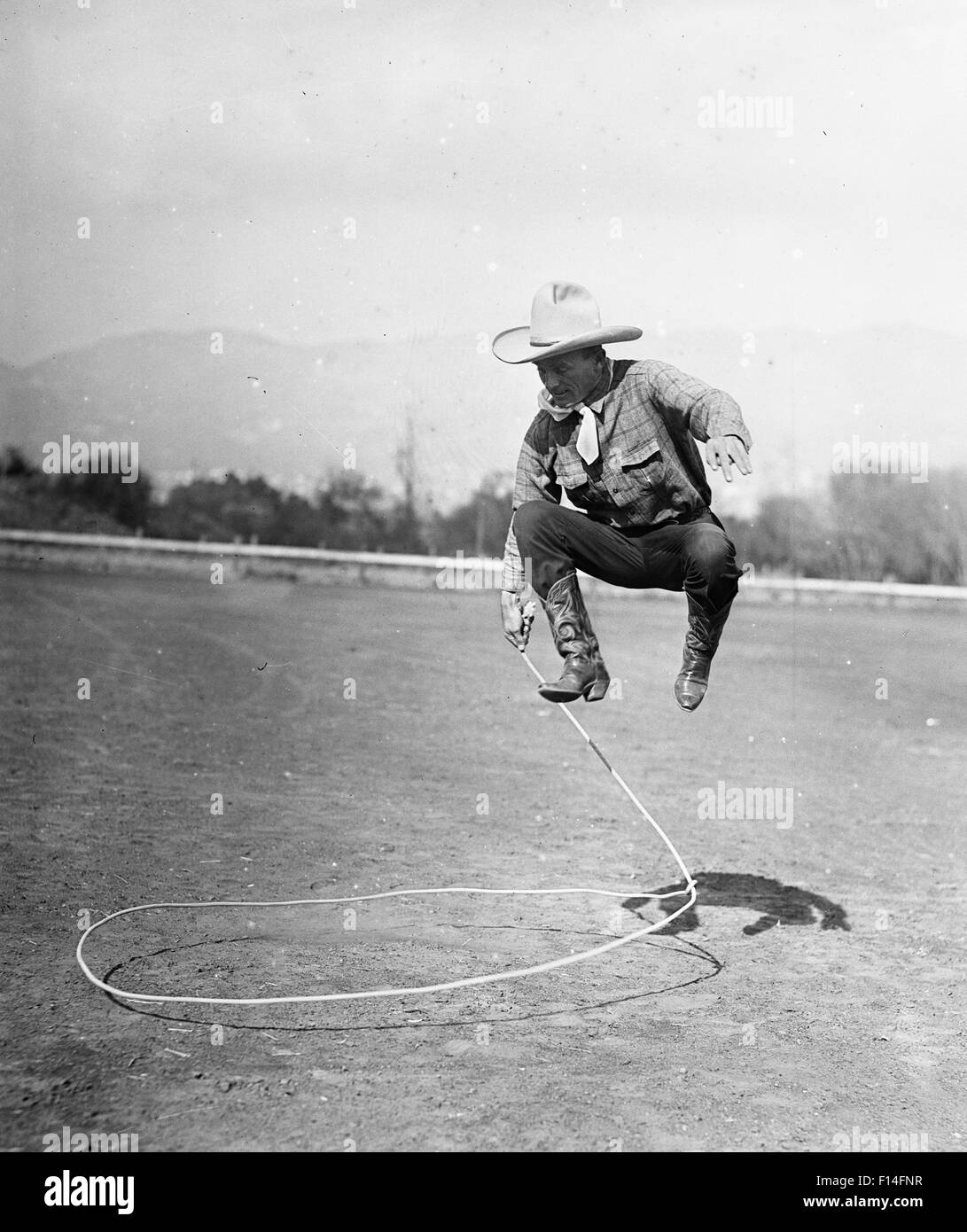 1930 L'HOMME FAIRE COWBOY TOUR DE CORDE À SAUTER EN L'AIR AVEC LASSO Photo  Stock - Alamy
