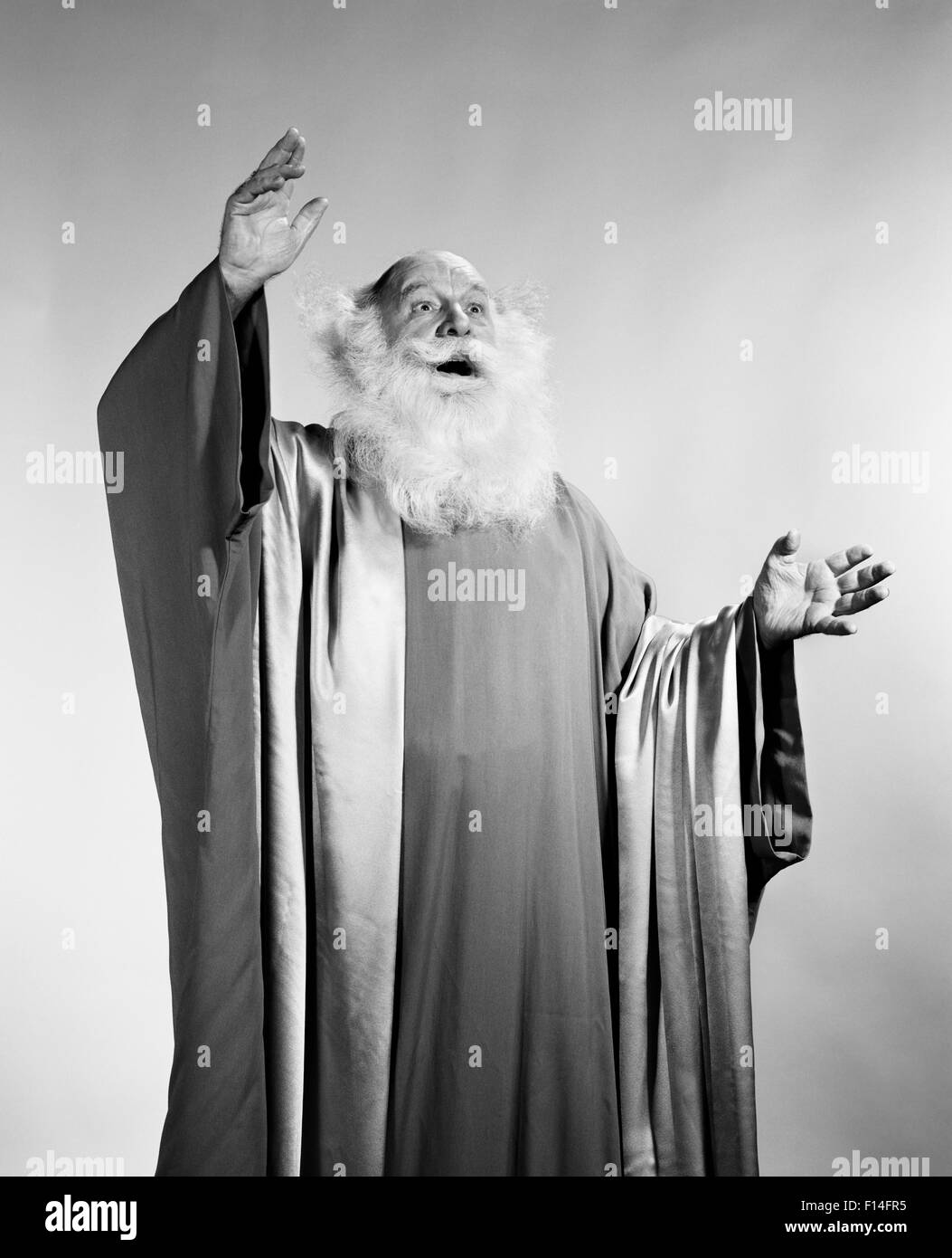 1960 MAN barbe blanche robes longues bras levés mystique PRÉDICATEUR ORACLE SEER Fortune Teller Banque D'Images