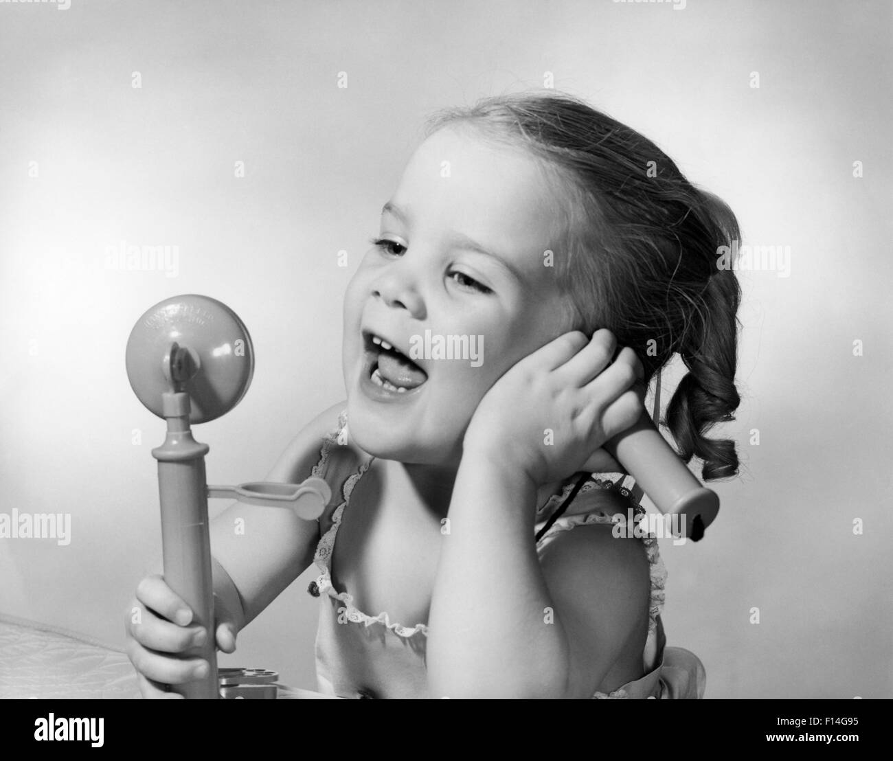 1950 HAPPY LITTLE GIRL PARLE DANS TOY Téléphone Banque D'Images