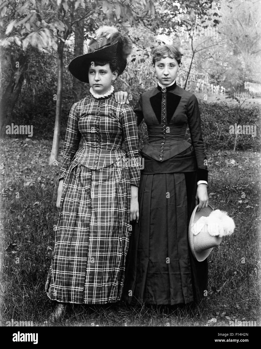 1890 1890 PORTRAIT DE DEUX ADOLESCENTES DEBOUT DANS UNE PELOUSE ARRIÈRE FILLES MAIN SUR L'épaule d'autres filles Banque D'Images