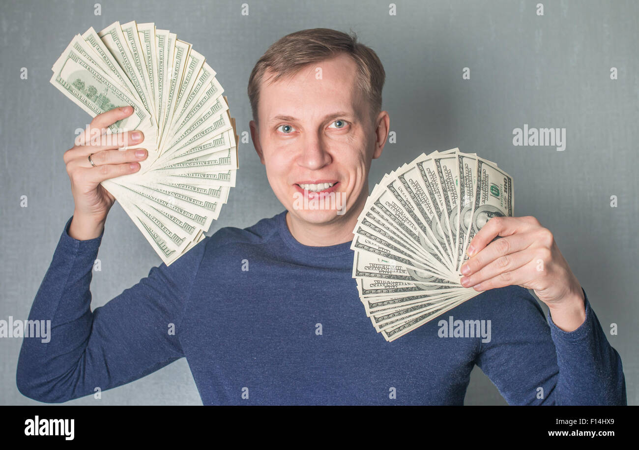 L'homme avide de l'affichage d'une propagation des dollars en espèces Banque D'Images