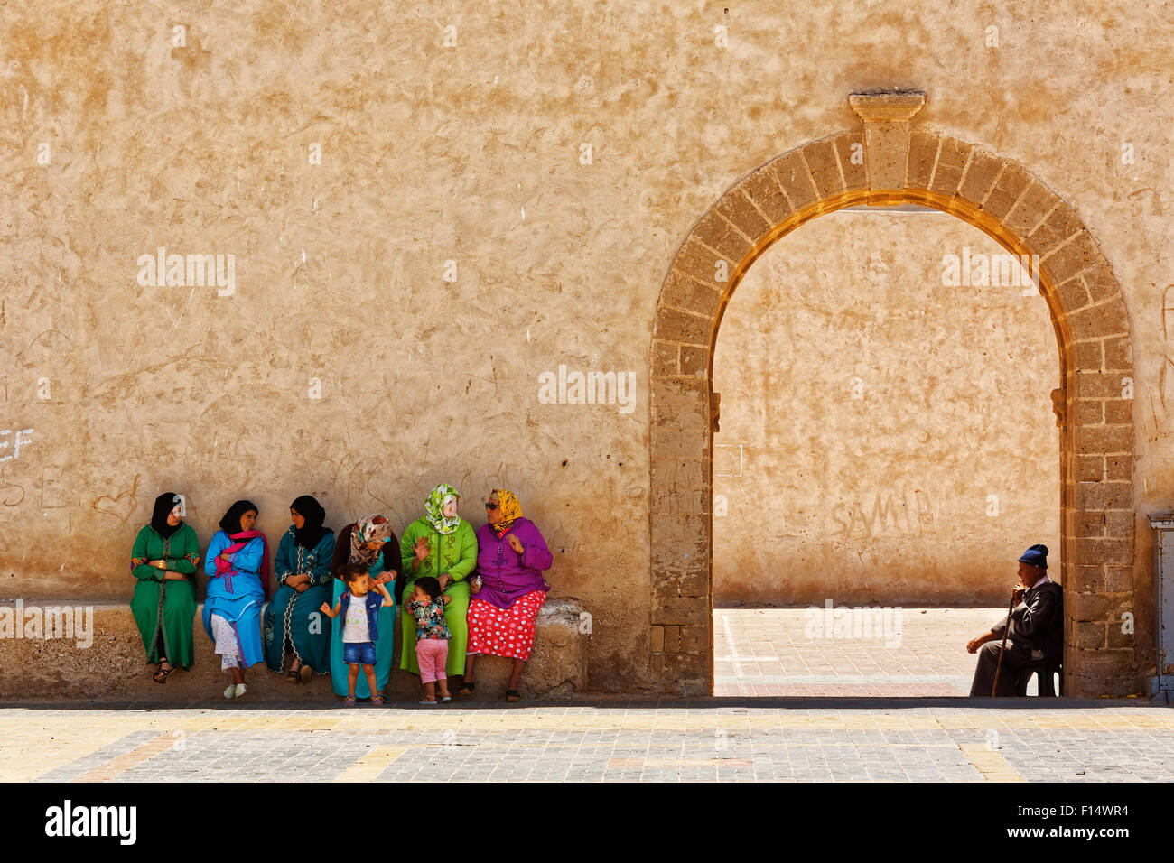 Les marocains s'asseoir près de l'entrée de la médina d'Essaouira Ville de Côte Atlantique, Maroc Banque D'Images