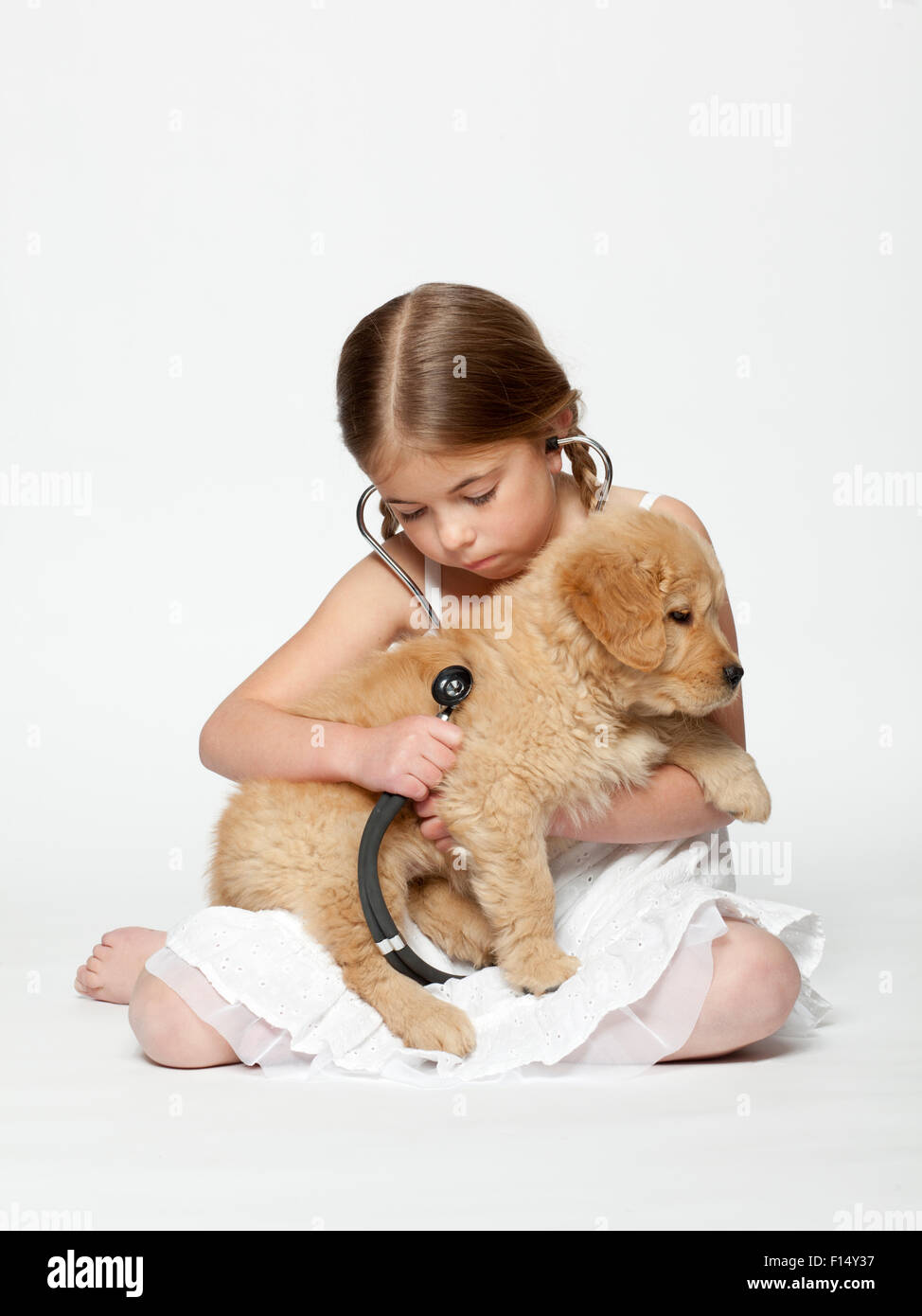 Portrait of Girl (6-7) l'examen de puppy with stethoscope Banque D'Images