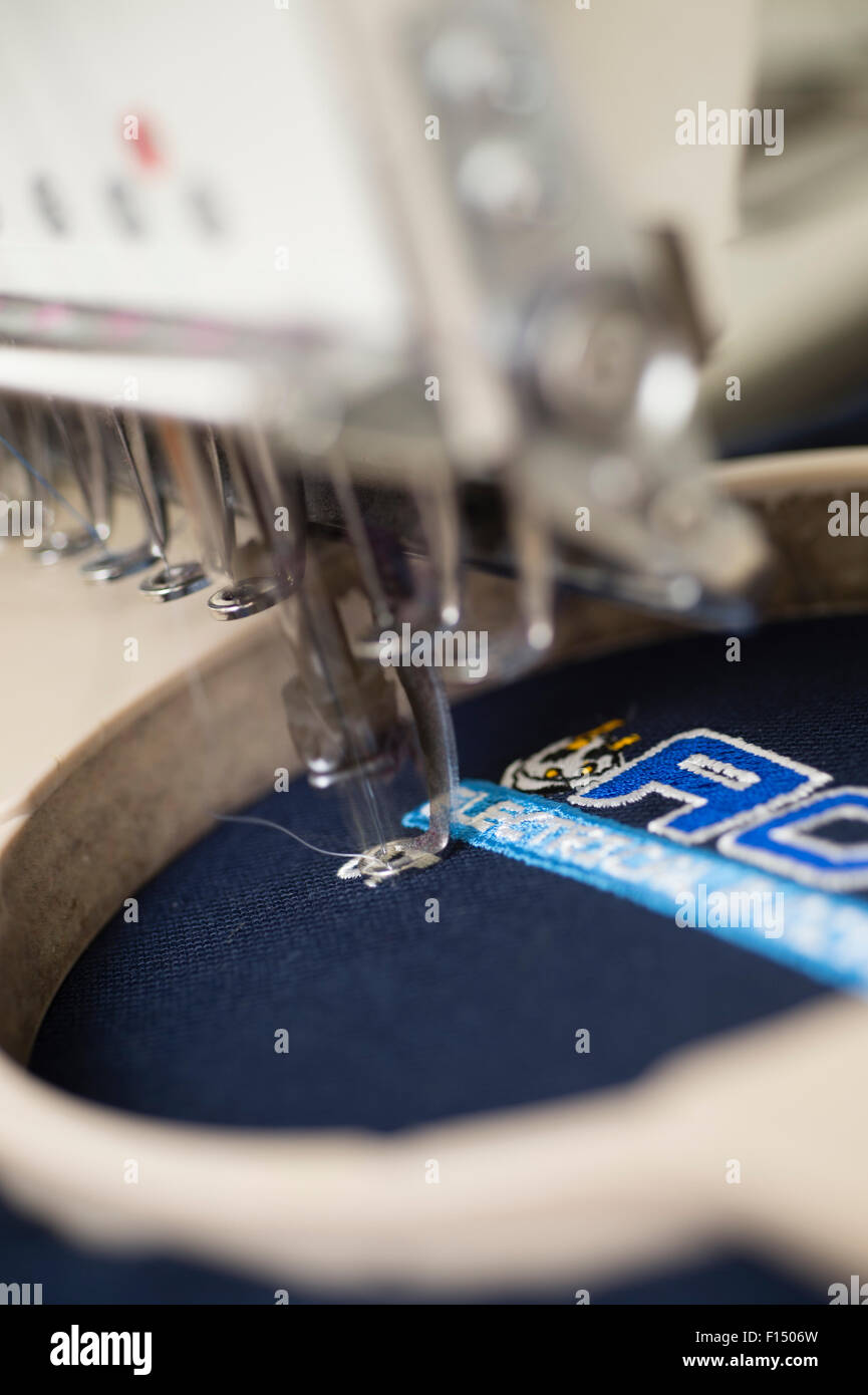 Close up detail d'une machine à broder de travail dans une entreprise de vêtements de sport et d'affaires UK atelier broderie Banque D'Images