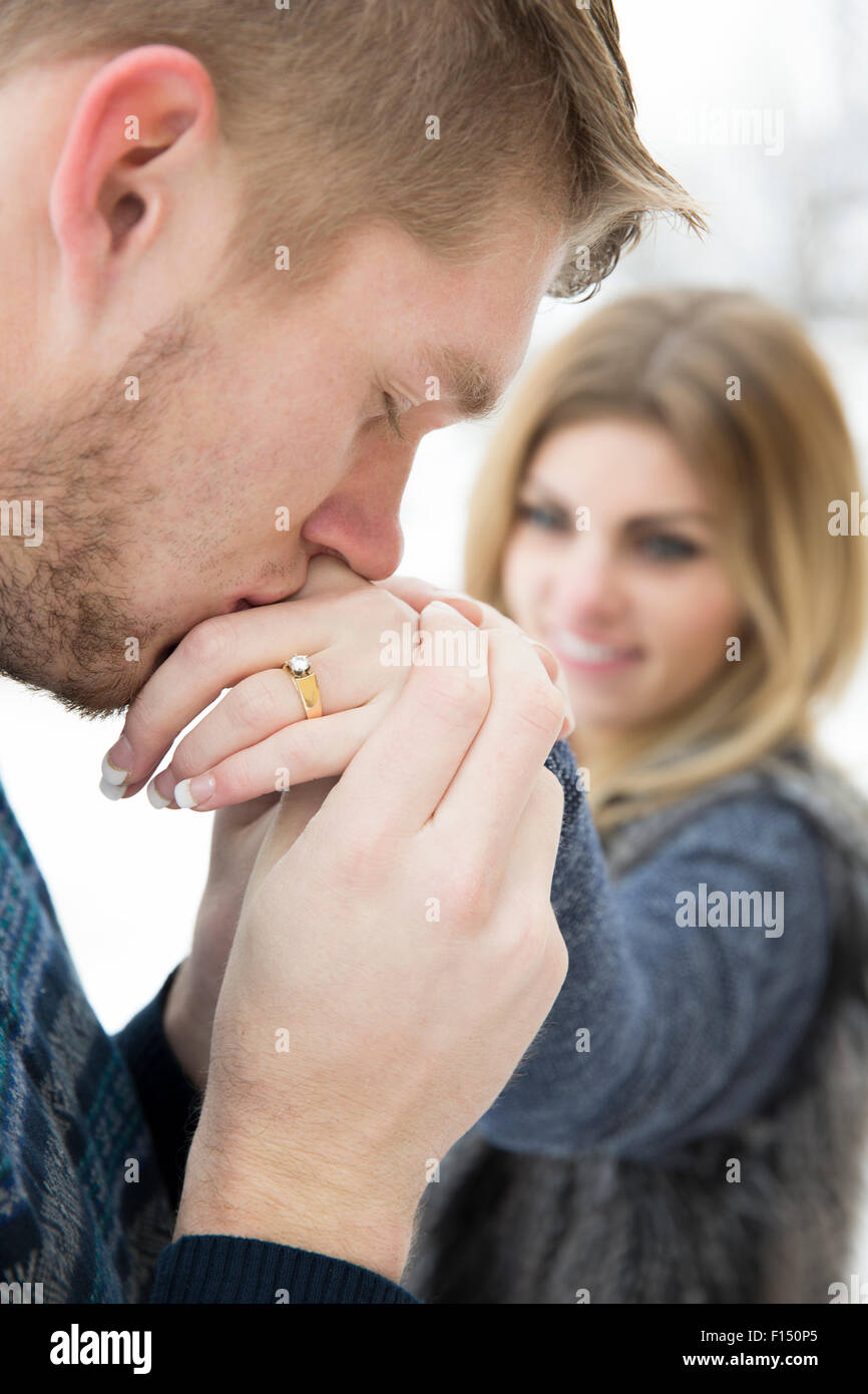 Close up of man kissing fiancees part avec bague de fiançailles sur le doigt Banque D'Images