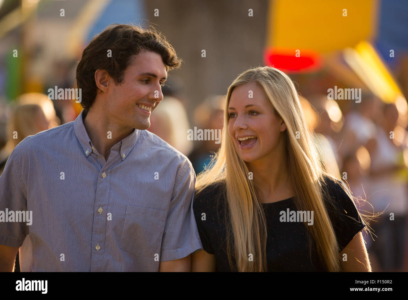 Couple heureux de parler et marcher au parc d'amusement juste Banque D'Images