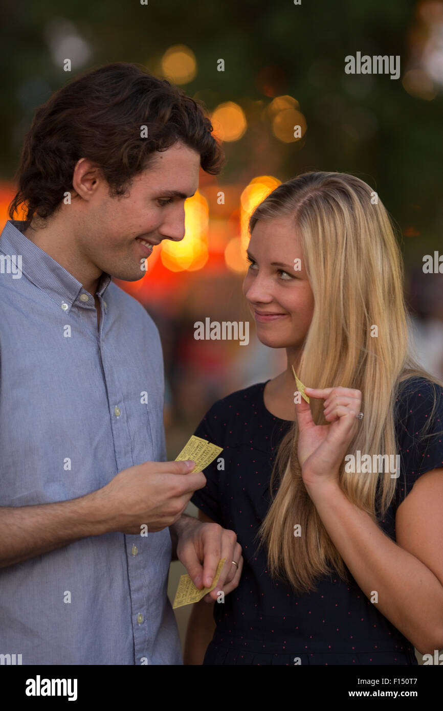Le partage ludique heureux couple snack au parc d'amusement juste Banque D'Images