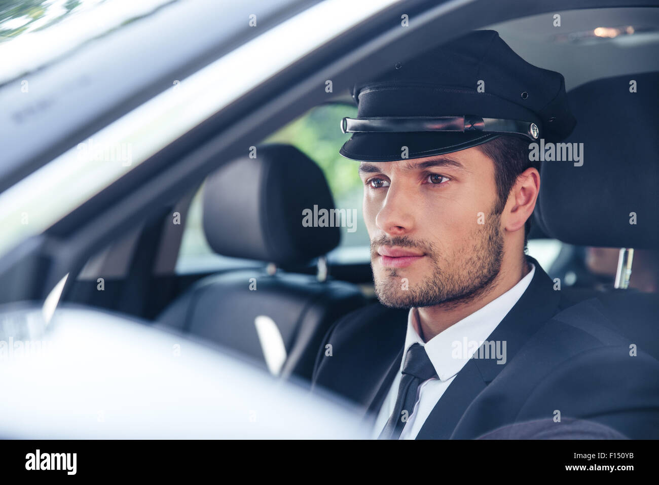 Portrait d'un beau mâle assise dans une voiture avec chauffeur Banque D'Images