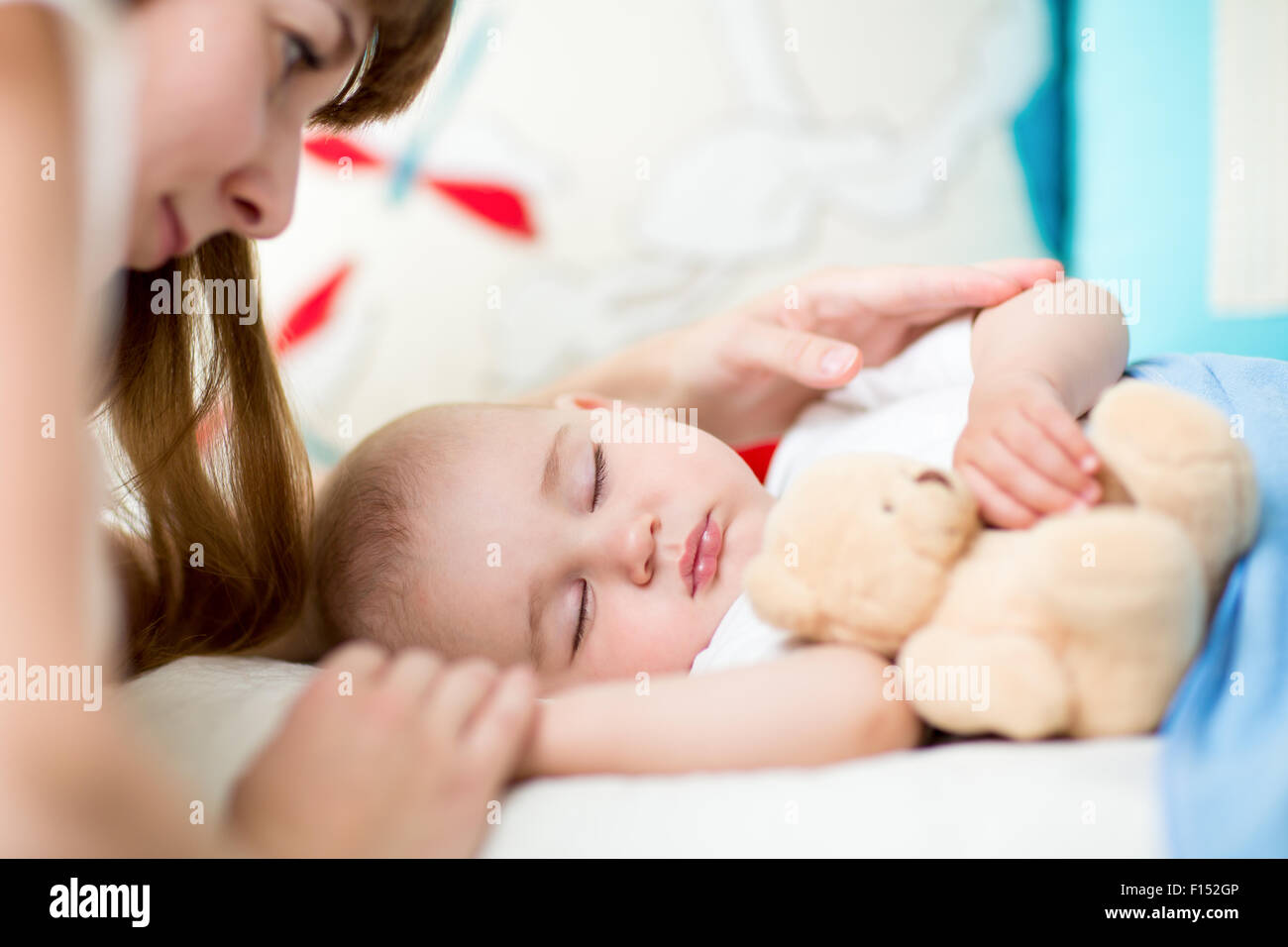 Jeune maman et bébé, sleeping in bed Banque D'Images