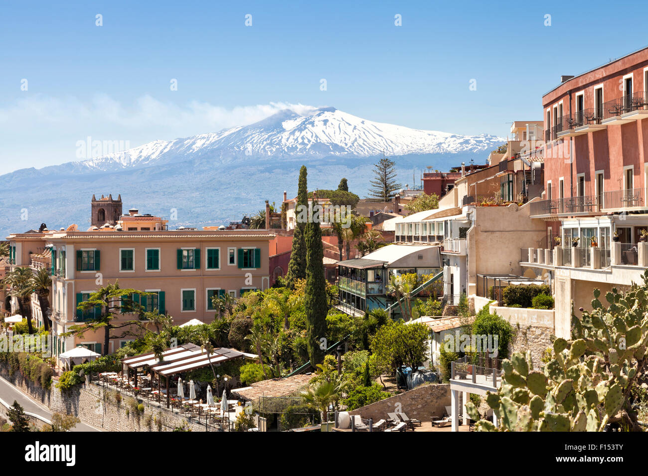 Vue panoramique de la ville sicilienne historique de Taormine, à l'arrière-plan avec le pic blanc du volcan Etna avec de la fumée sur Hot spring Banque D'Images