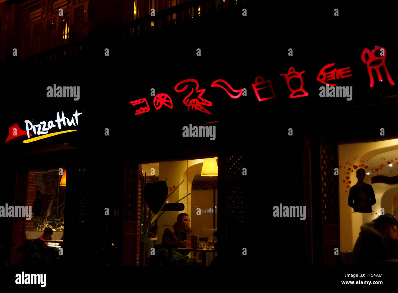 Restaurant Pizza Hut de nuit avec l'écriture pictographique Naxi dans le Yunnan, Chine Banque D'Images