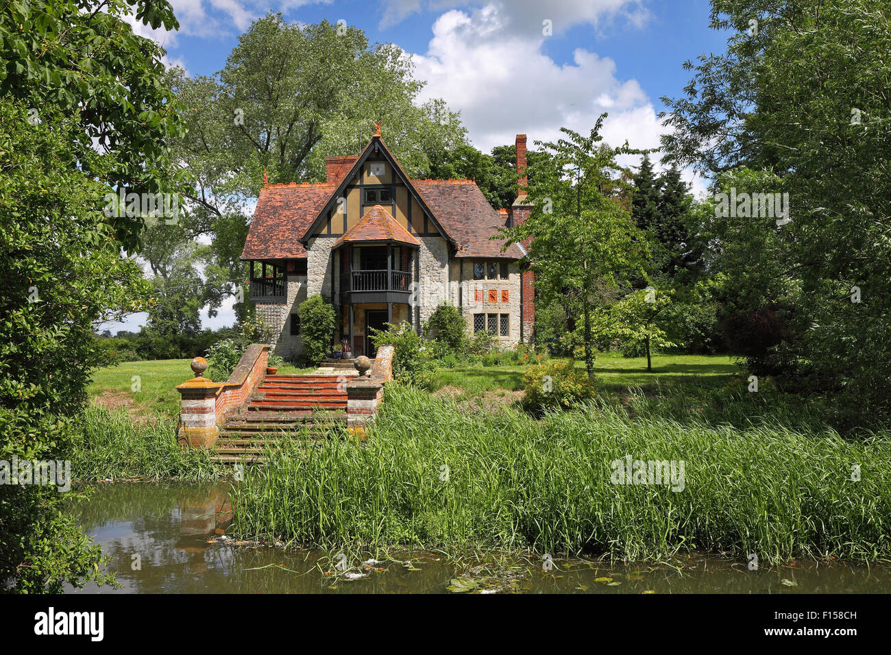 Riverside cottage anglais pittoresque avec des marches menant à bord de l'eau Banque D'Images
