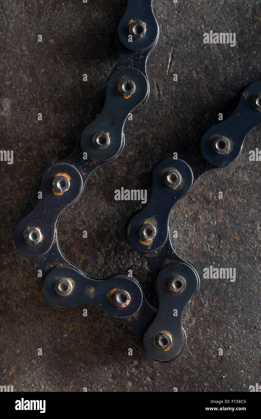 Liens d'une chaîne de vélo sur une plaque d'acier rouillé Banque D'Images
