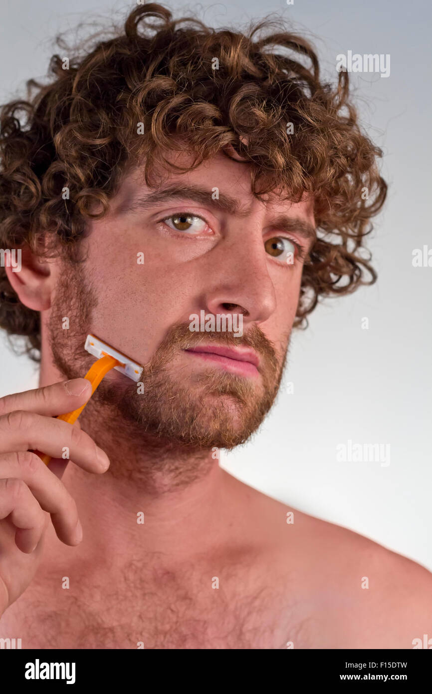 L'homme aux cheveux bouclés grave off se rase sa barbe Photo Stock - Alamy