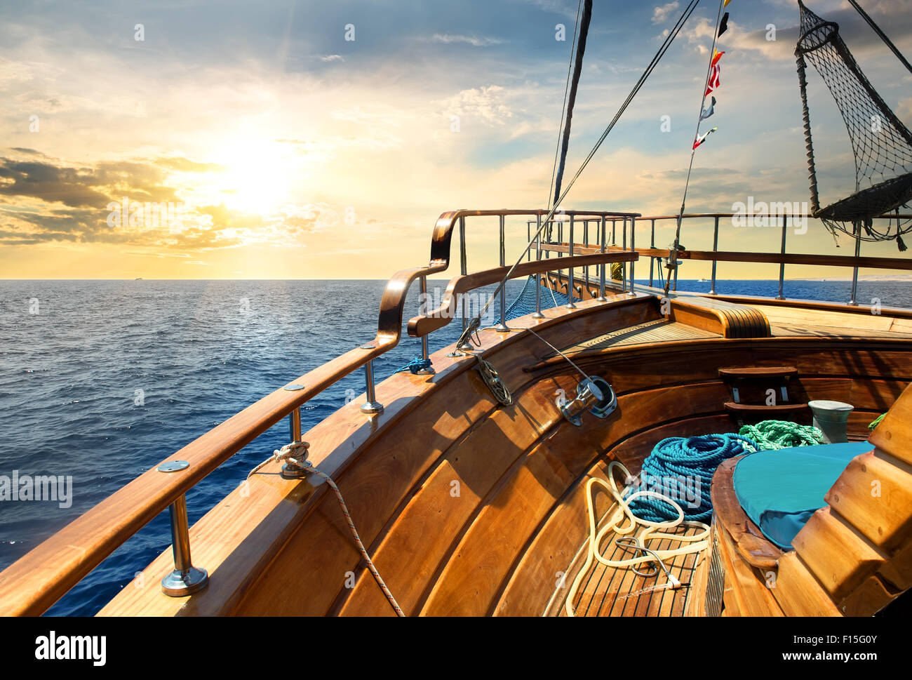 Voilier en bois dans la mer au lever du soleil Banque D'Images