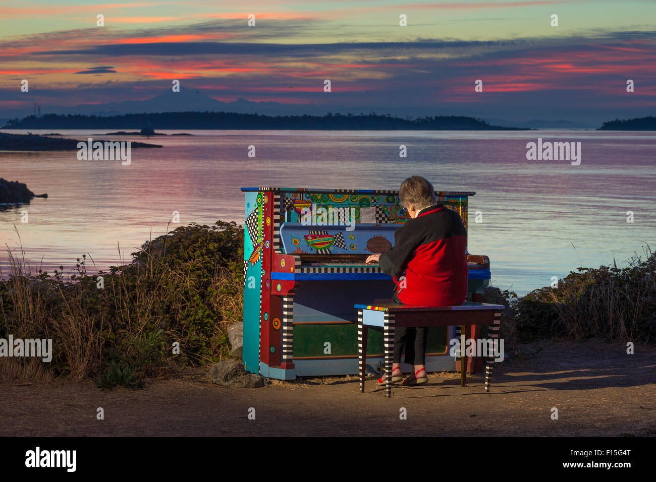 Senior citizen woman playing piano coloré avant le lever du soleil-Victoria, Colombie-Britannique, Canada. Banque D'Images