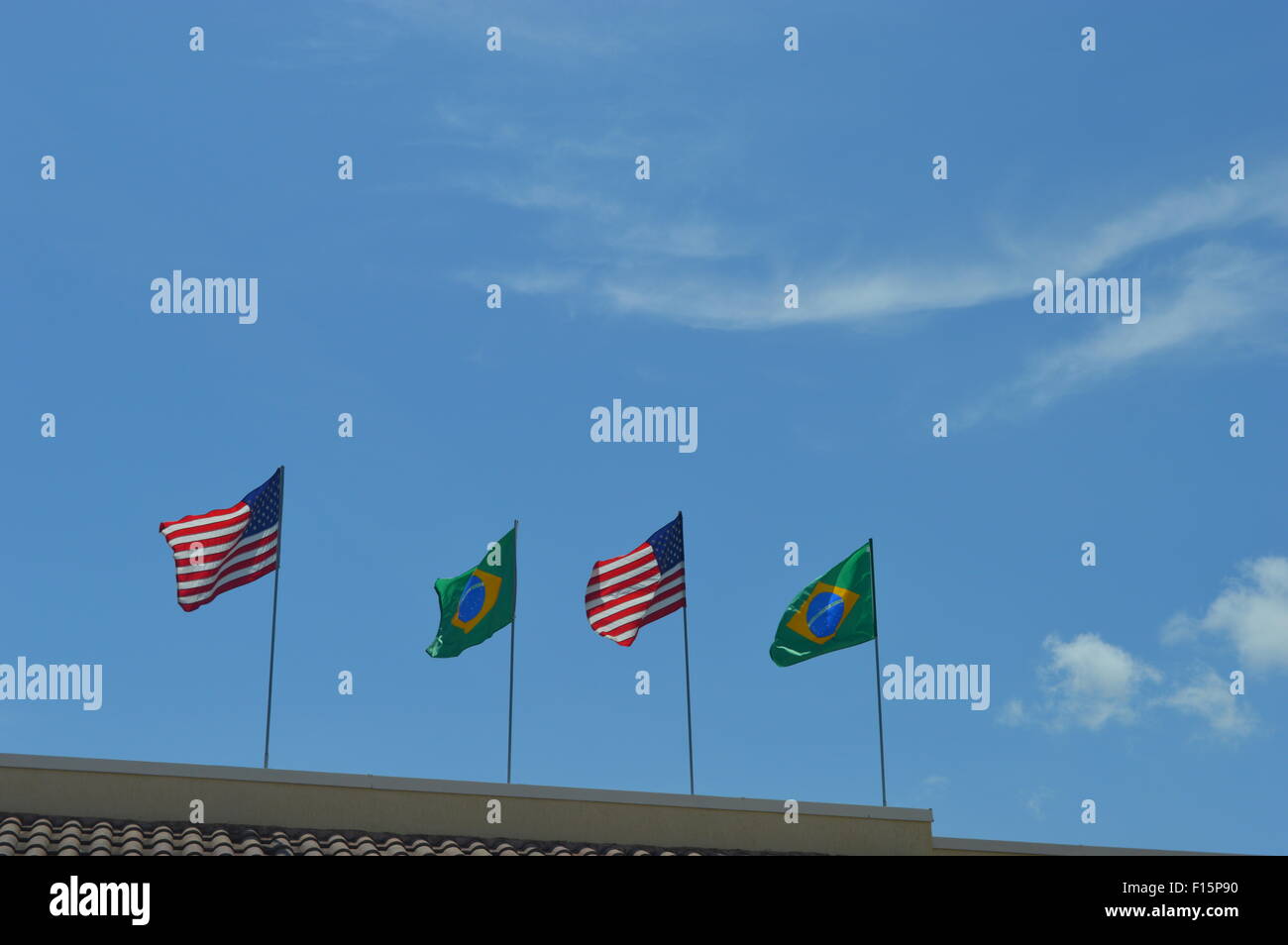 Drapeaux américains et brésiliens sur le dessus d'un bâtiment contre le ciel Banque D'Images