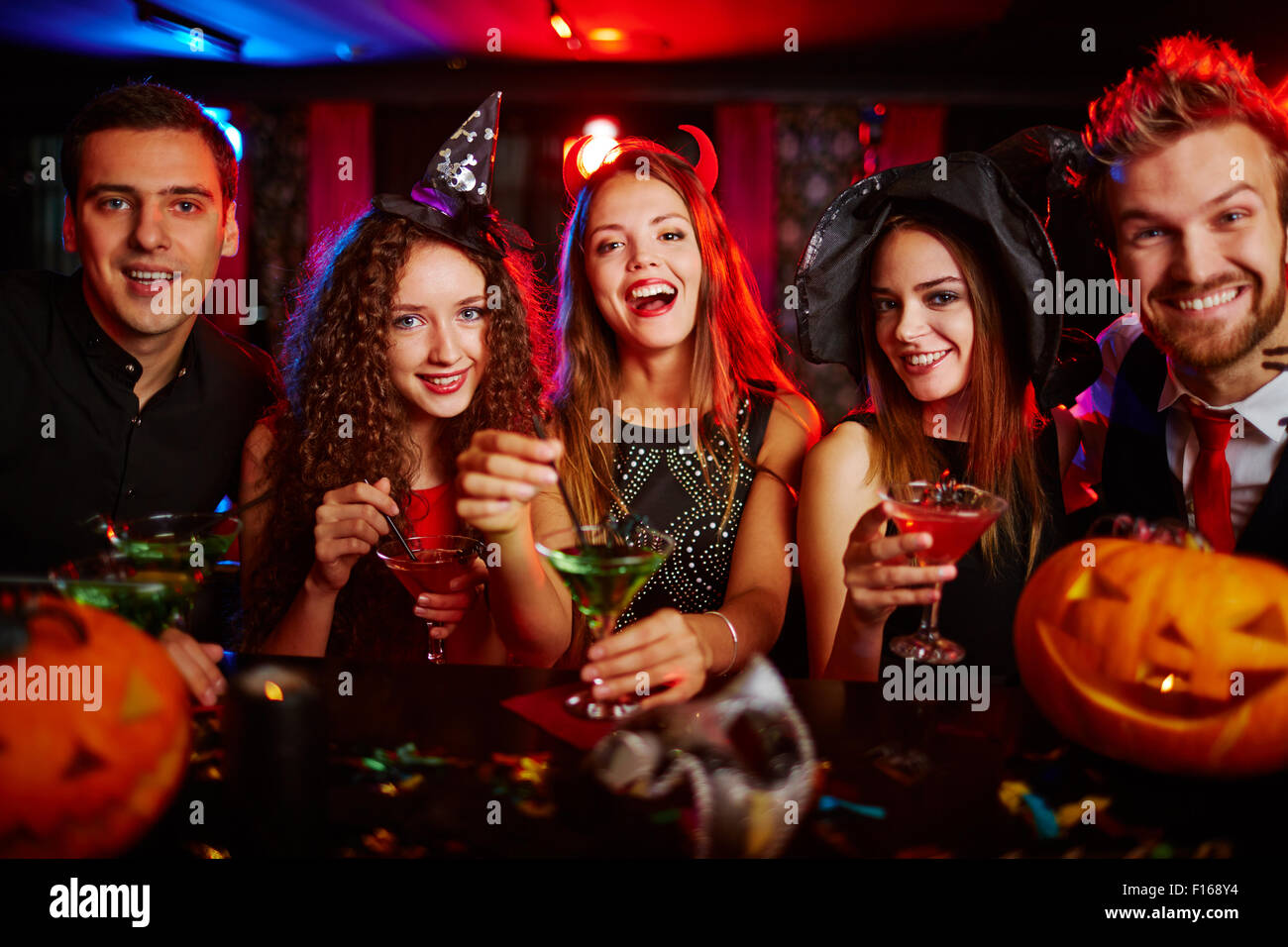 Les amis se reposant dans une discothèque à l'Halloween Banque D'Images