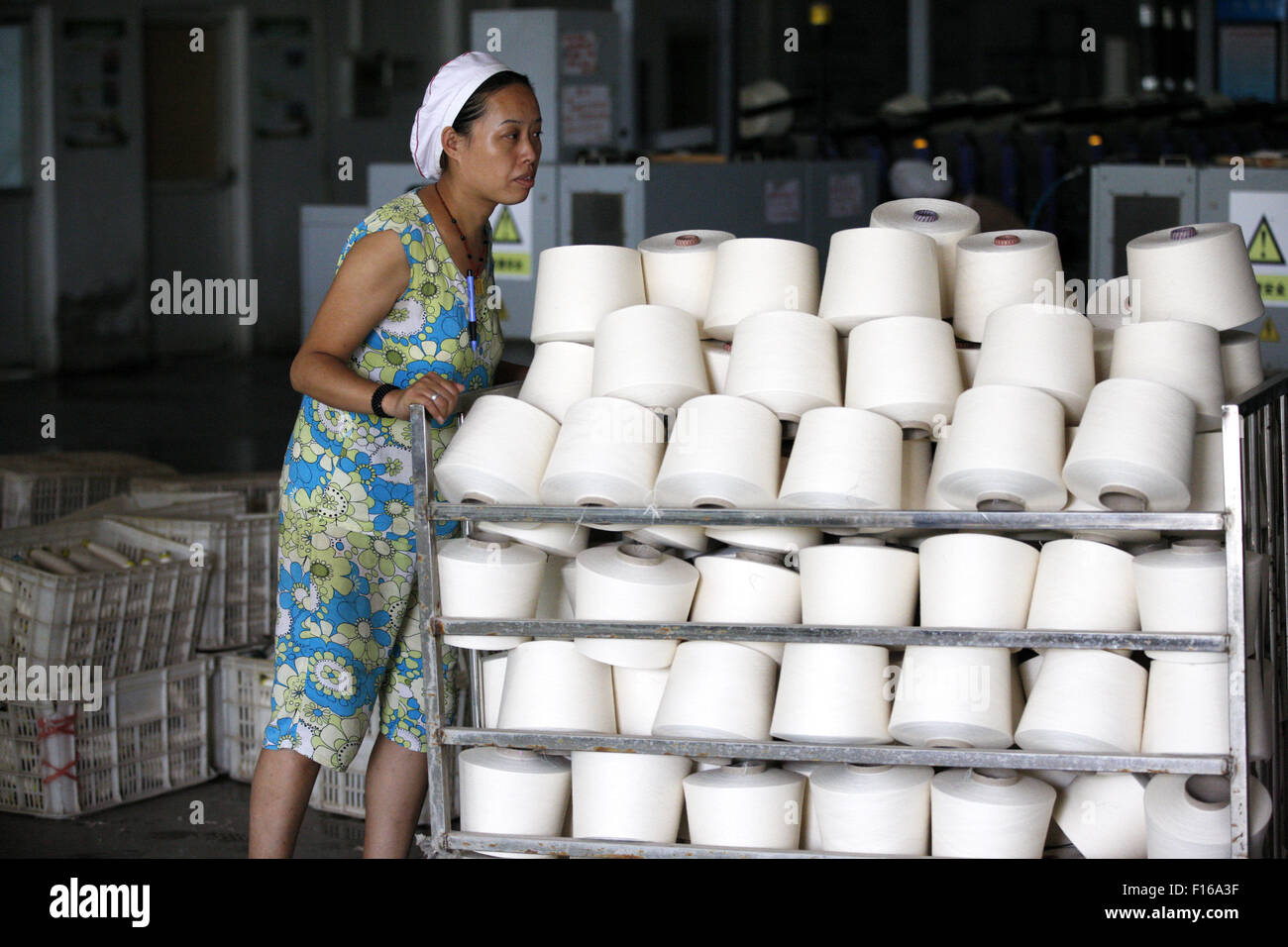 Un travail dans une usine de textile à Huaibei, province de Anhui, Chine, le 28 août 2015. Les bénéfices réalisés par les entreprises industrielles chinoises ont diminué en juillet .bénéfices industriels ont diminué de 2,9 % par rapport à l'année à partir de 471,56 milliards de dollars en juillet à la suite d'une hausse de 0,3 % le mois précédent, le Bureau National des Statistiques a montré vendredi Banque D'Images