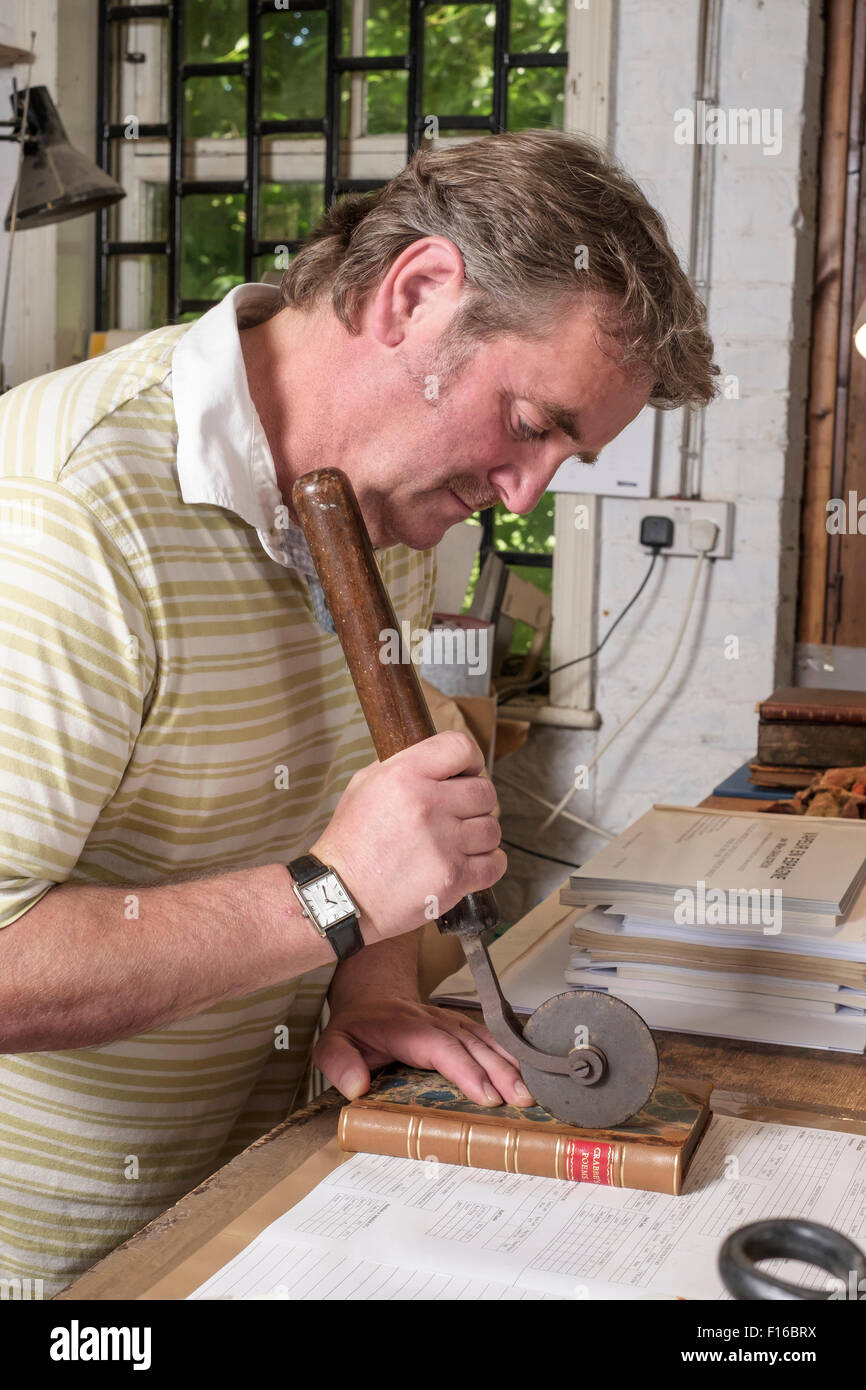 Dans l'homme, avec les outils traditionnels de travail atelier de reliure Banque D'Images