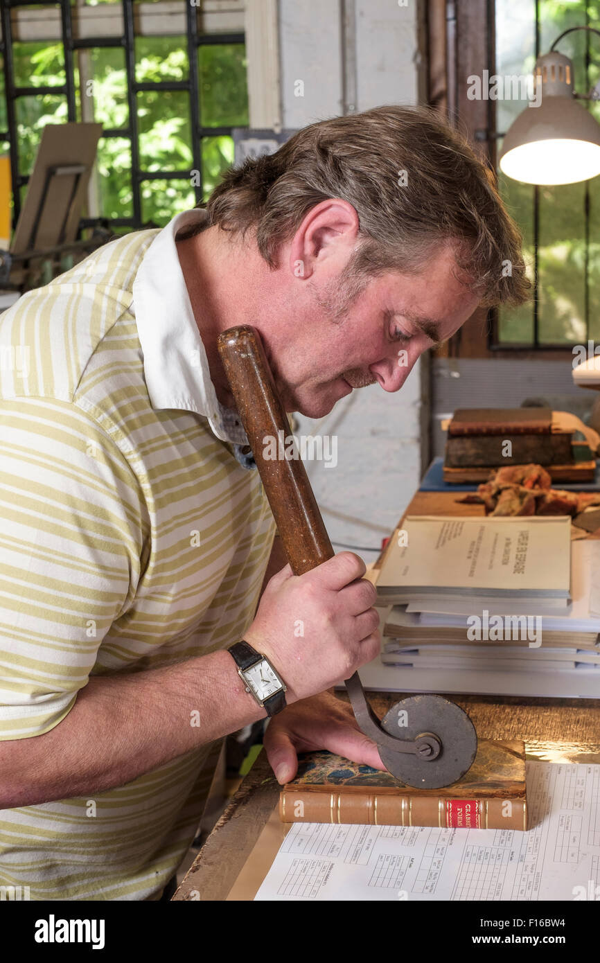 L'homme la restauration d'un livre avec les outils traditionnels Banque D'Images
