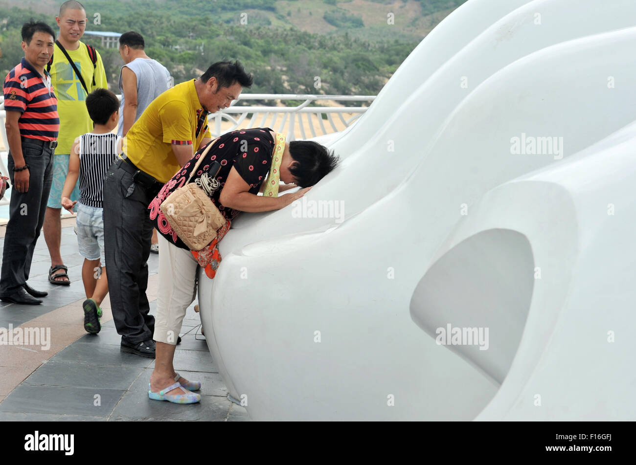 Sanya, province de Hainan en Chine. Août 28, 2015. Les gens prient au pied des 108 mètres de haut statue de bodhisattva Avalokitesvara à Nanshan resort de Sanya, Chine du sud de la province de Hainan, le 28 août 2015. Dans le calendrier lunaire, c'est aujourd'hui le 15e jour du septième mois, qui s'appelle festival Ullambana, certaines activités Bouddhistes se tiendra sur ce jour. Crédit : Yang Guanyu/Xinhua/Alamy Live News Banque D'Images