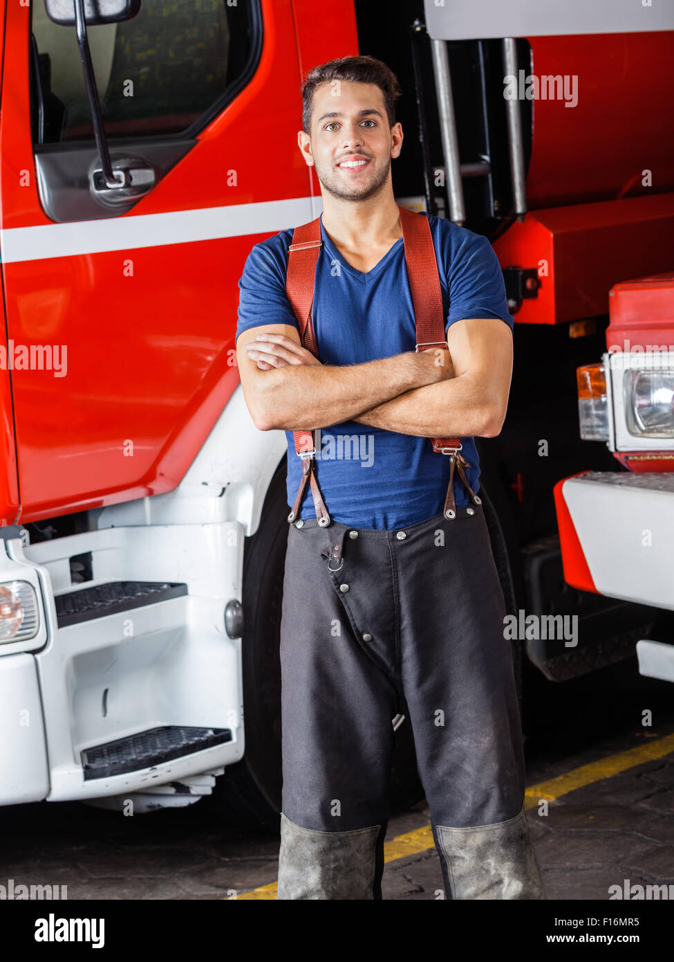 Smiling firefighter standing arms crossed Banque D'Images