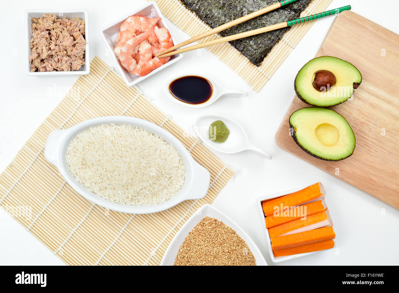 Capture d'un grand angle d'une table avec une partie des ingrédients pour préparer des sushi et des outils, tels que des nattes de bambou, riz à sushi, thon, avoca Banque D'Images