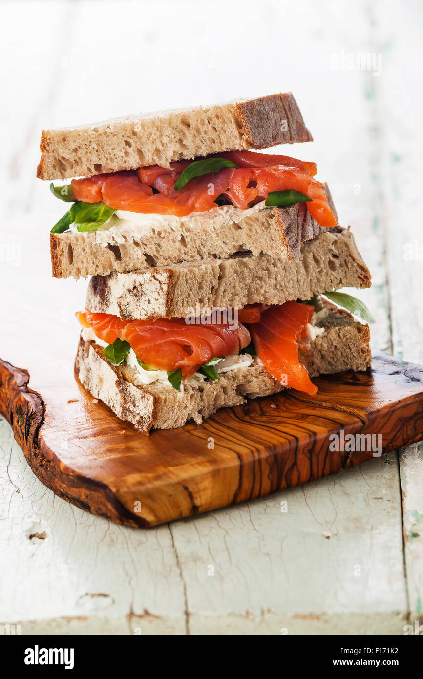 Sandwich avec saumon fumé, poisson rouge bleu sur fond de bois Banque D'Images