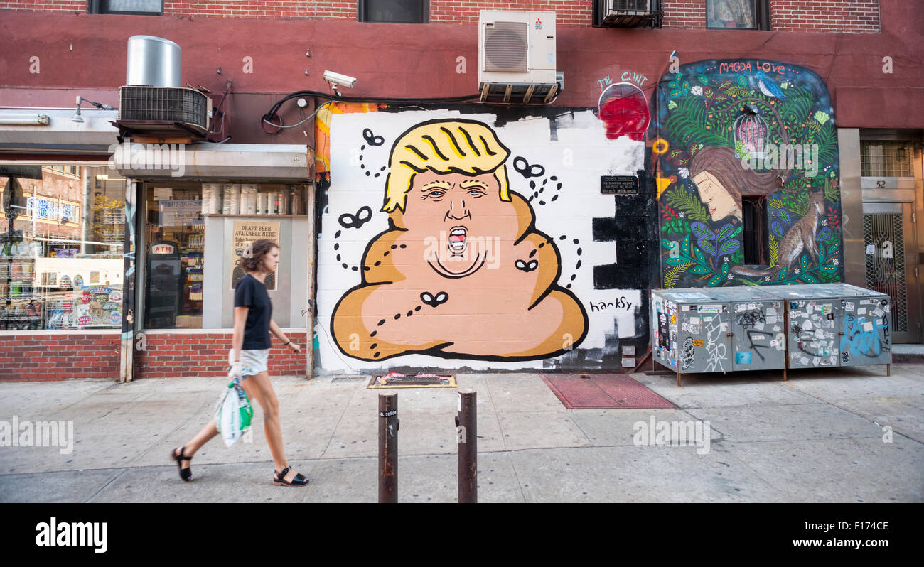 New York, New York, USA. Août 28, 2015. Passant à pied en face d'une peinture murale par l'artiste de rue Hanksy dans le Lower East Side de New York représentant d'affaires et candidat aux élections présidentielles, Donald Trump comme un tas d'excréments de mouches sur bourdonnement, vu le Vendredi, Août 28, 2015. Hanksy est connu pour son jeu rempli de nombreuses œuvres mettant en vedette Tom Hanks. Crédit : Richard Levine/Alamy Live News Banque D'Images