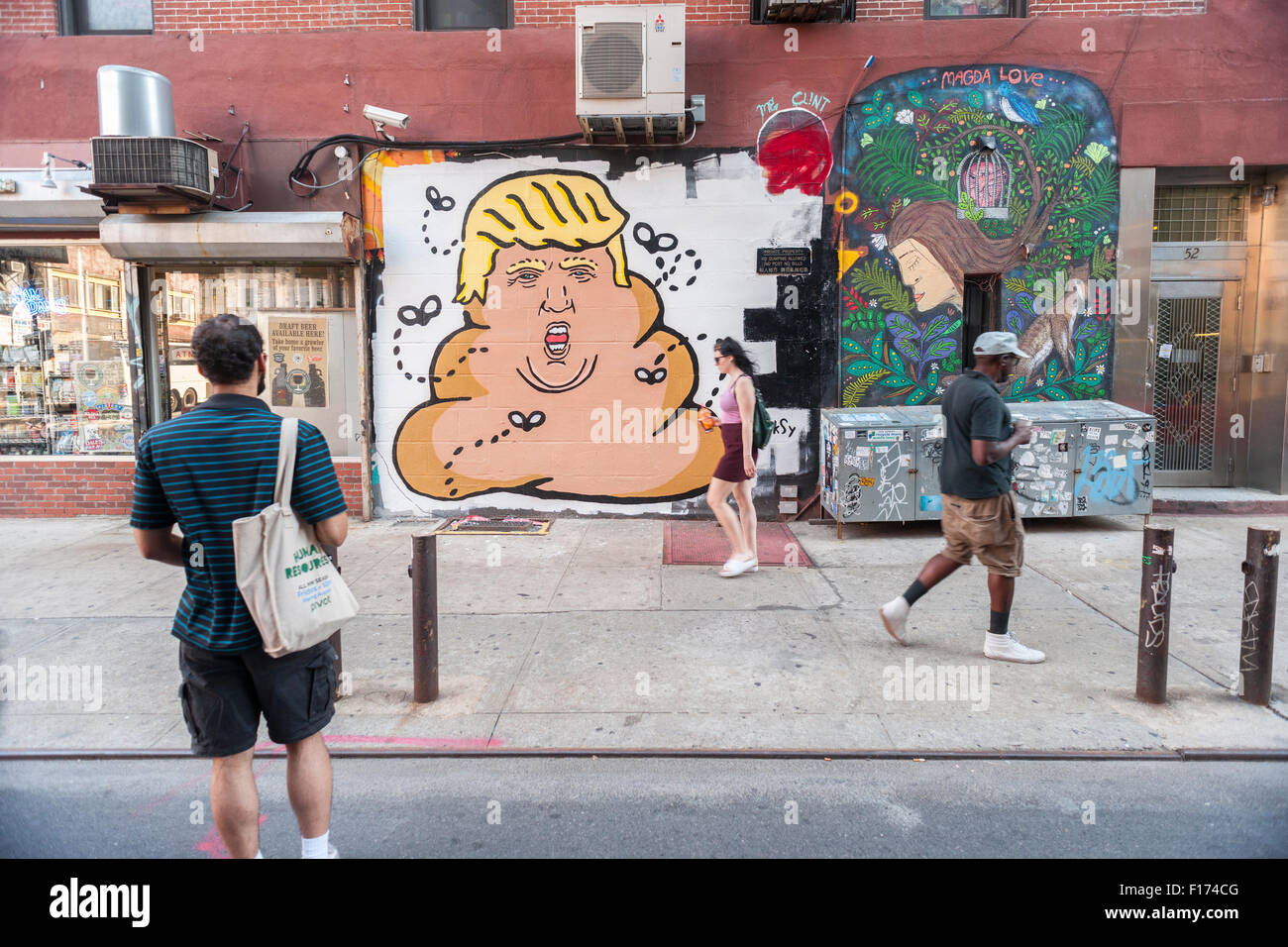 New York, New York, USA. Août 28, 2015. Passant à pied en face d'une peinture murale par l'artiste de rue Hanksy dans le Lower East Side de New York représentant d'affaires et candidat aux élections présidentielles, Donald Trump comme un tas d'excréments de mouches sur bourdonnement, vu le Vendredi, Août 28, 2015. Hanksy est connu pour son jeu rempli de nombreuses œuvres mettant en vedette Tom Hanks. Crédit : Richard Levine/Alamy Live News Banque D'Images