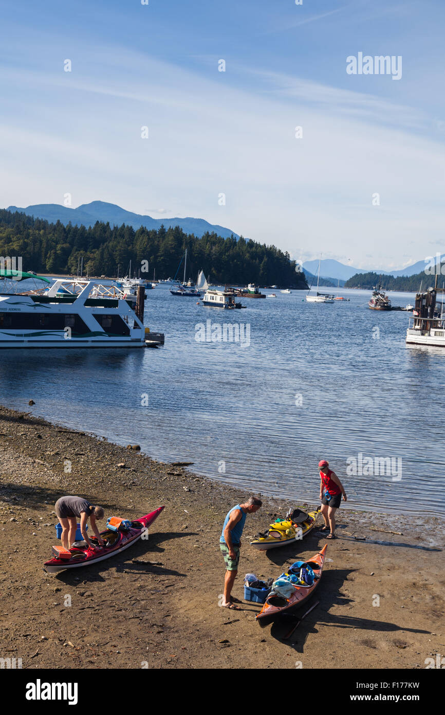 Trois personnes kayaks d'emballage pour un long voyage de pagaie, Sechelt, Colombie-Britannique Banque D'Images