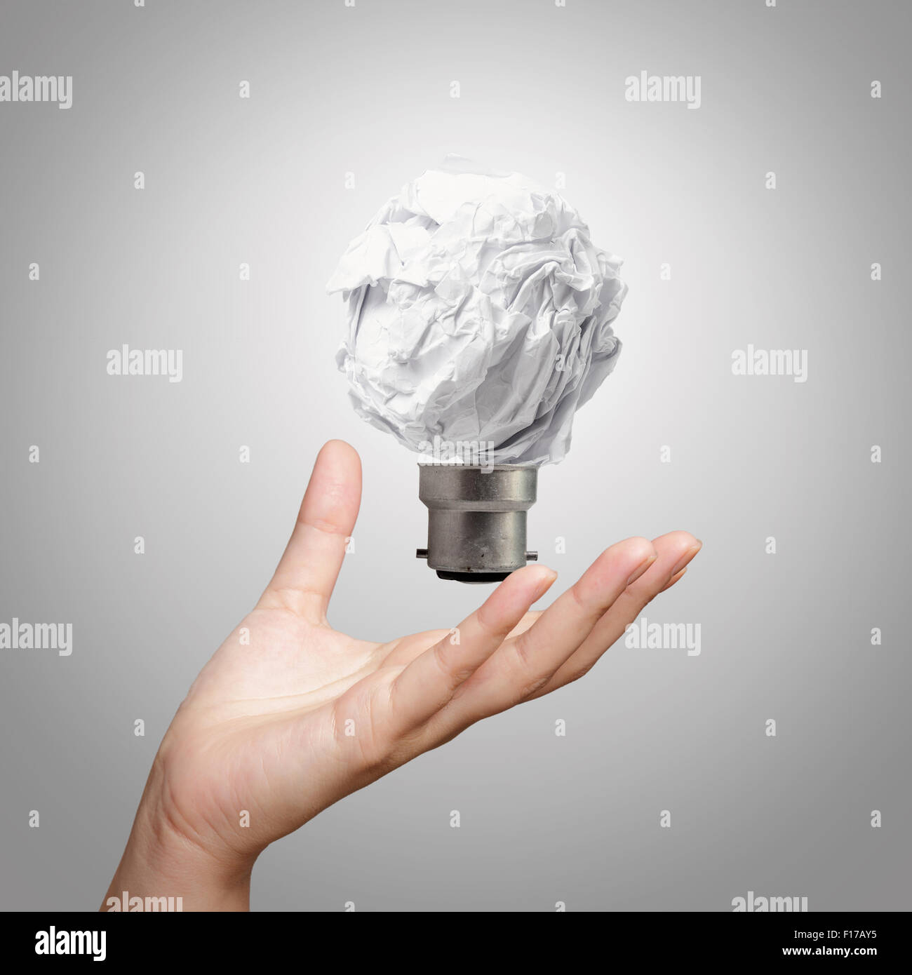 La lampe de la main montrant papier froissé comme concept créatif Banque D'Images