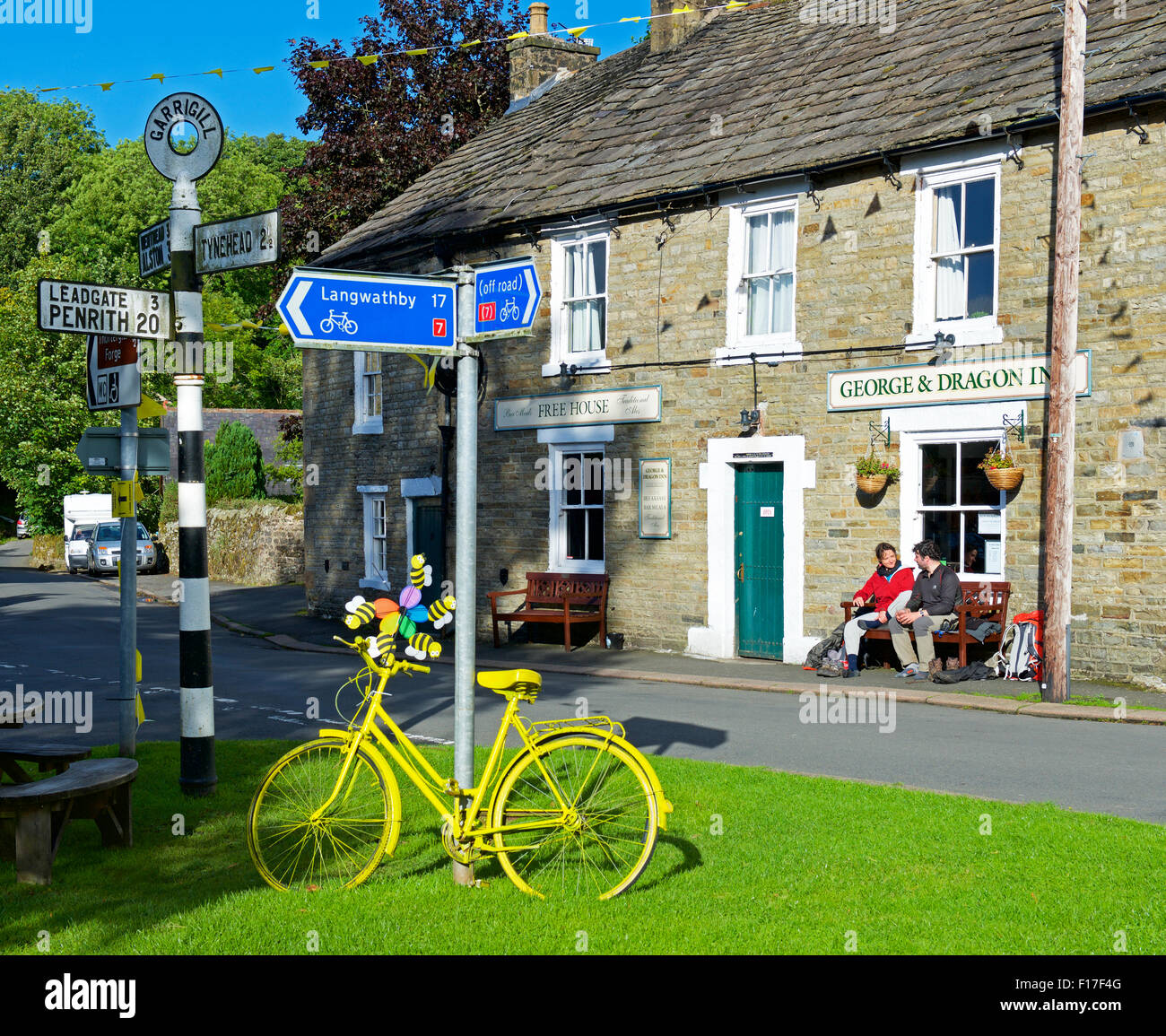 Deux marcheurs Pennine Way assis dehors le George & Dragon pub, dans le village d'Garrigil, Cumbria, Angleterre, Royaume-Uni Banque D'Images