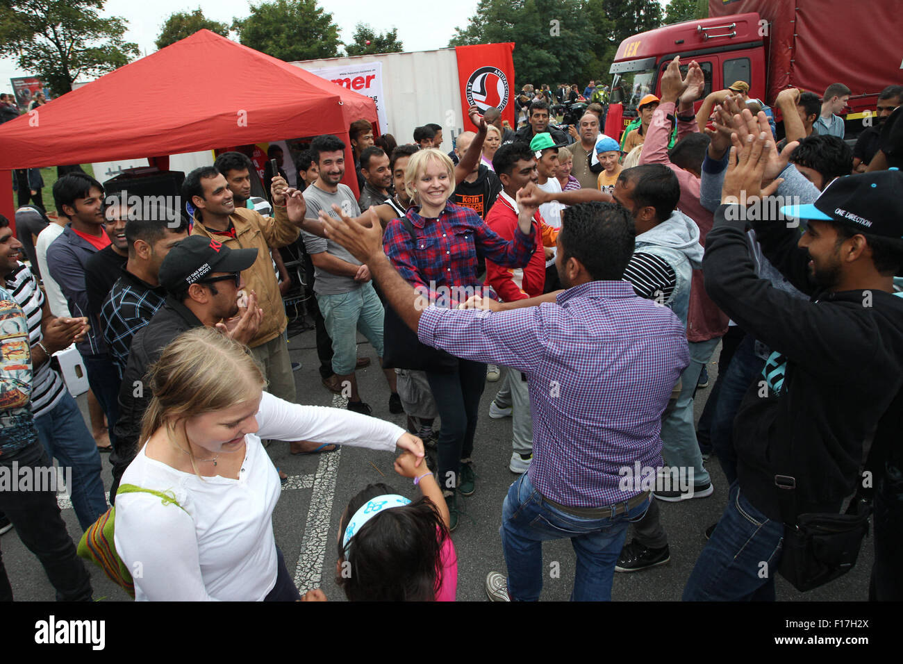 Heidenau, Allemagne. Août 28, 2015. Les réfugiés et les partisans danser ensemble dans les rues au cours d'une partie d'accueil pour les réfugiés à Heidenau, Allemagne, 28 août 2015. Le groupe de citoyens 'Dresden' Nazifrei (Dresde gratuitement de Nazis) a organisé l'événement pour accueillir l'arrivée de réfugiés à Heidenau. Photo : Sebastian Willnow/dpa/Alamy Live News Banque D'Images