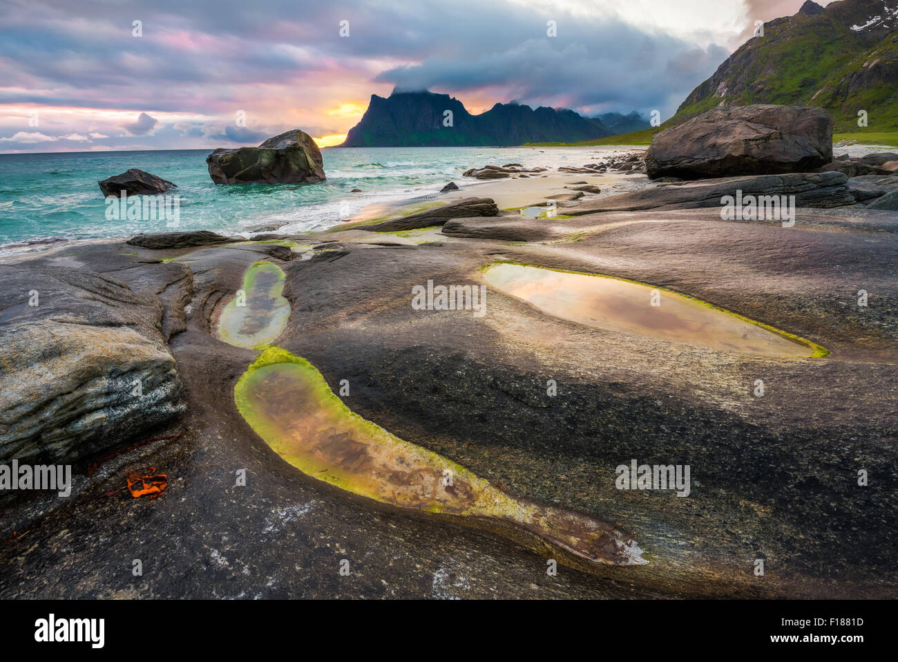 Plus de coucher de soleil spectaculaire sur la plage Uttakleiv îles Lofoten en Norvège avec un étang naturel au premier plan. Traitement HDR. Banque D'Images