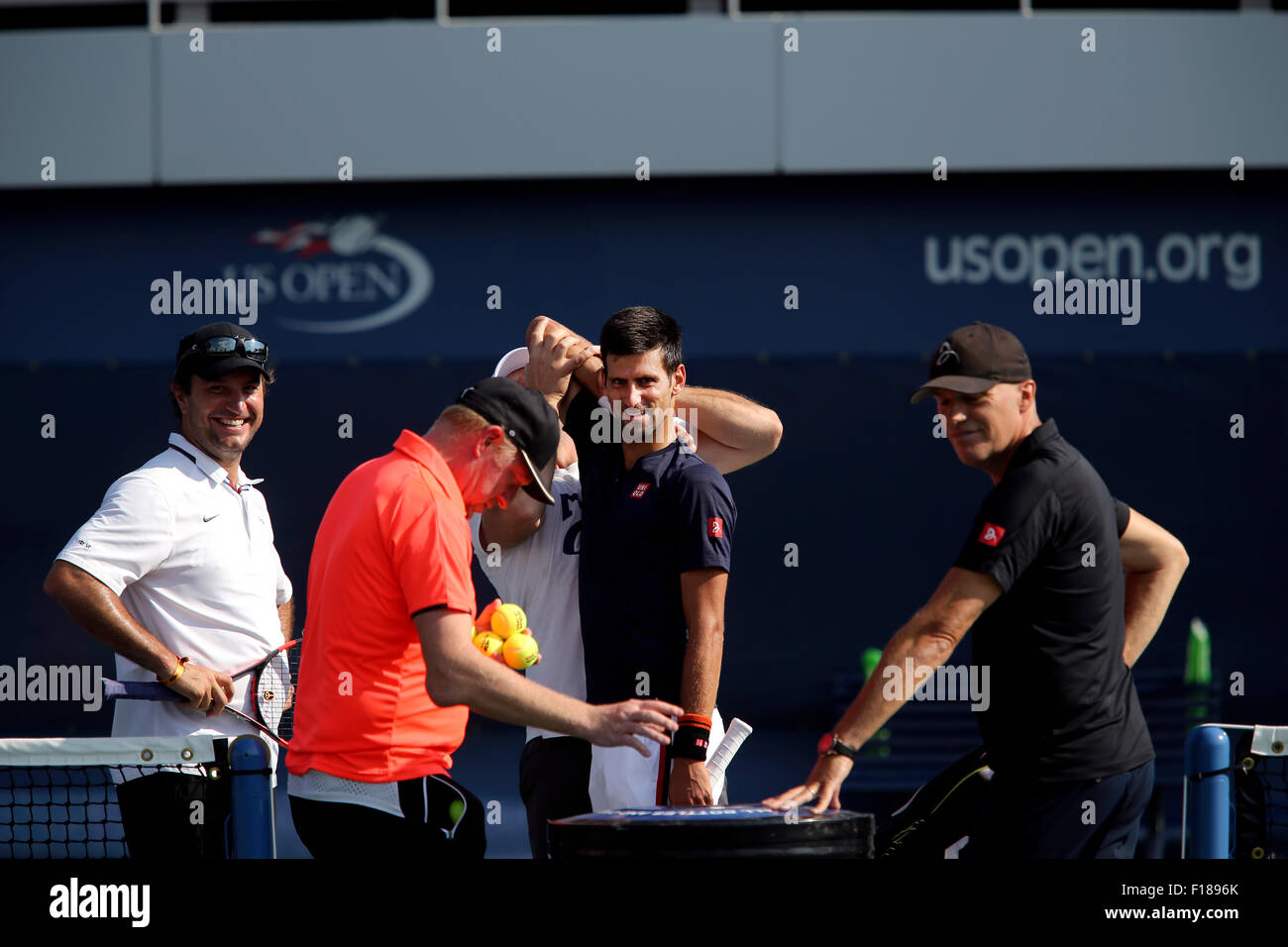 New York, USA. Août 29, 2015. Numéro un Novak Djokovic gagne un peu d'aide s'étend pendant une séance d'essai à l'USTA Billie Jean King National Tennis Center de Flushing Meadows, New York le Samedi, Août 29th, 2015. Il se prépare à l'US Open qui débute lundi. Dans l'avant-plan dans la chemise orange est coach, Boris Becker. Crédit : Adam Stoltman/Alamy Live News Banque D'Images