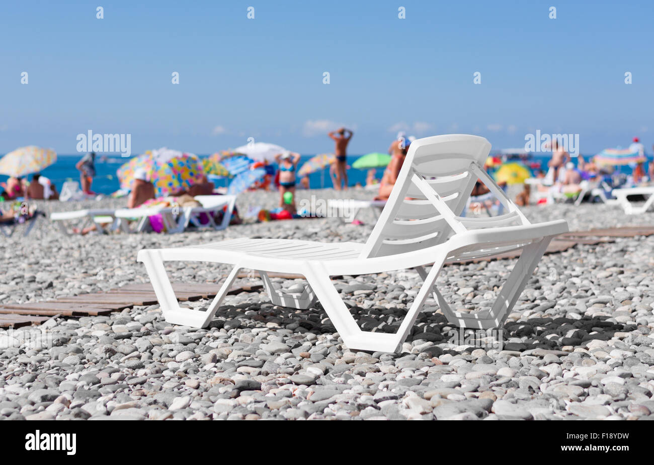 Plastique blanc chaise longue sur la plage par la mer sur l'arrière-plan of  Photo Stock - Alamy