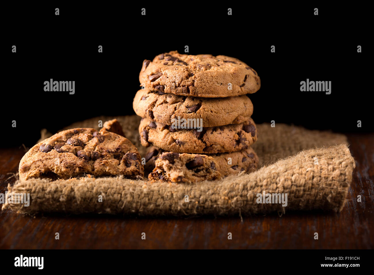 Cookies au chocolat blanc sur la serviette sur le linge de table en bois. Tourné sur un tissu de couleur café Banque D'Images