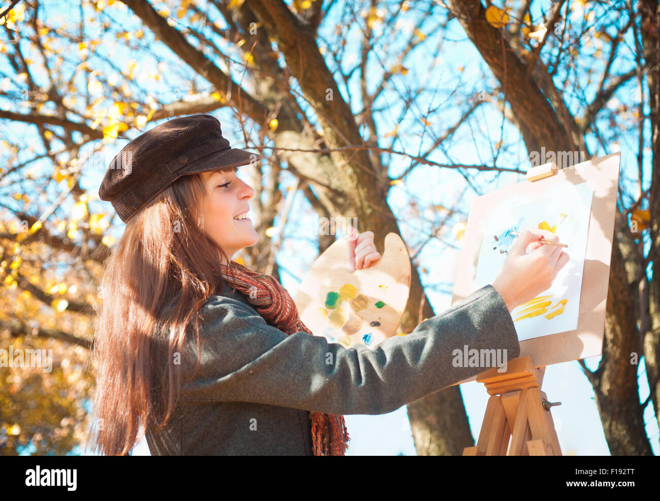 Portrait d'une belle jeune femme avec un pinceau dans sa main, à l'extérieur Banque D'Images