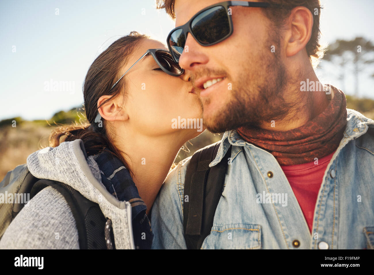 Jeune couple aimant touristique de randonnée. Jeune femme embrassant la joue de son petit ami, à l'extérieur sur une randonnée. Banque D'Images