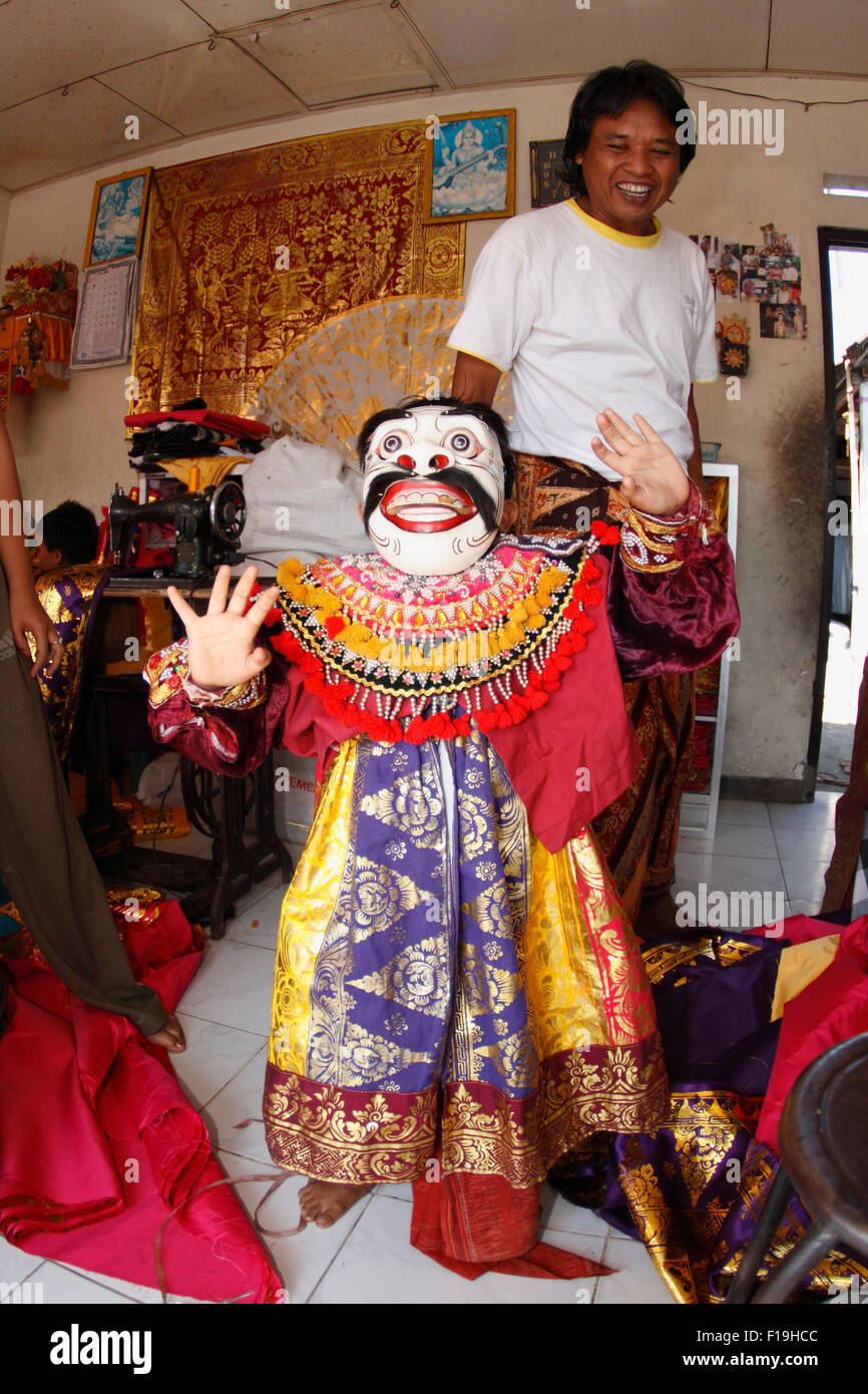 Px41795. Jeune garçon frappe un passer pour un danseur de barong, tandis que son père- un costume bouilloire- regarde sur. Bali, Indonésie. Banque D'Images