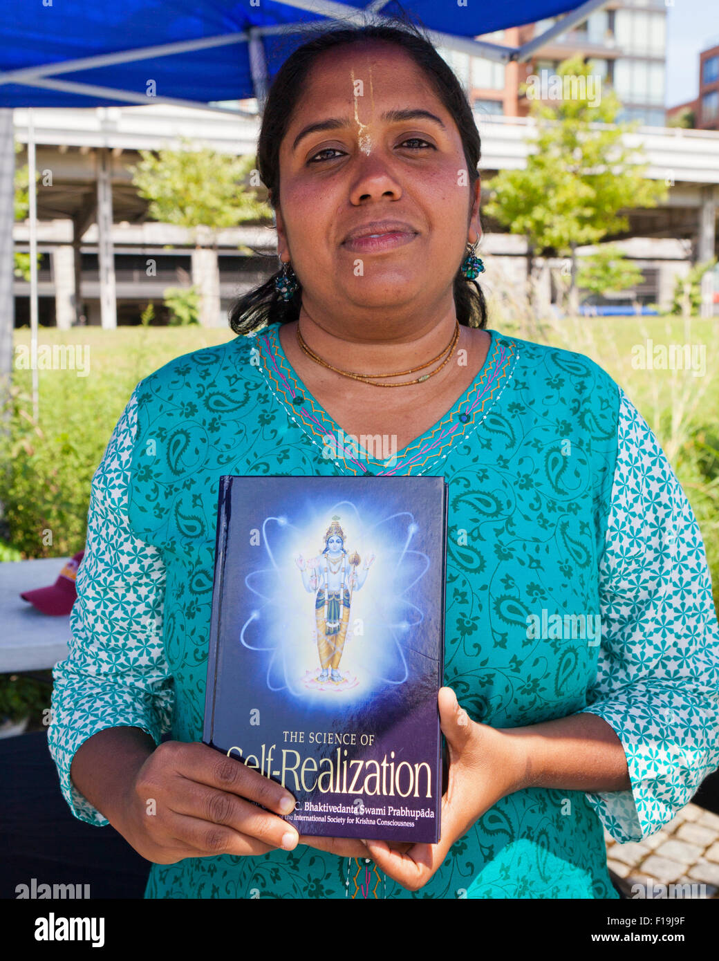Hare Krishna woman holding Self-Realization livre - USA Banque D'Images